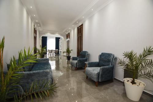 a lobby with blue chairs and a table with plants at House at the Sea in Batumi