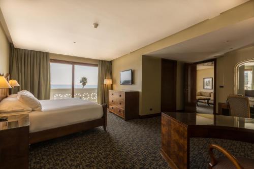 a hotel room with a bed and a view of the ocean at Enjoy Viña Del Mar in Viña del Mar