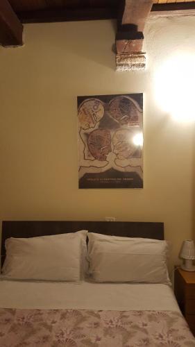 a bedroom with a bed with a picture on the wall at Via della Posterna in Spoleto