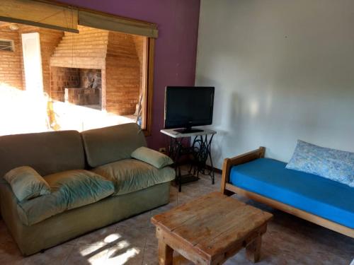 a living room with a couch and a table at QUINTA EN OPEN DOOR-LUJÁN in Luján