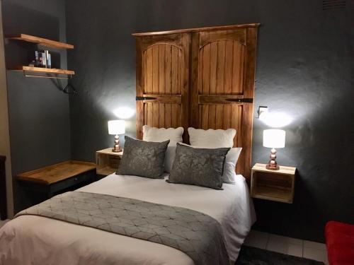 a bedroom with a large bed with two night stands at Green Hollow Self catering in Knysna
