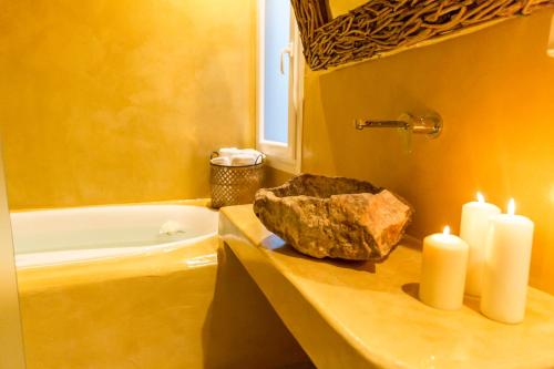 a bathroom with two candles and a rock on a counter at Margarita Hotel in Firostefani