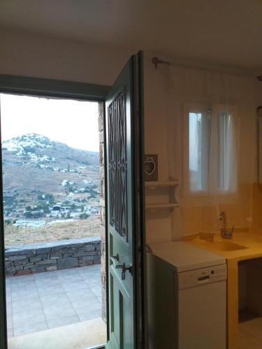 a kitchen with a door open to a view at Magda house in Livadi