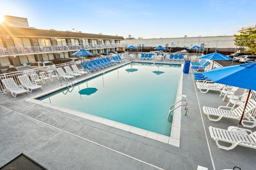 a large swimming pool with several tables and chairs at Harris House by the Beach in Ocean City