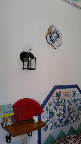 een muur met een klok en een plank op een muur bij Hostal la Ninfa in Granada