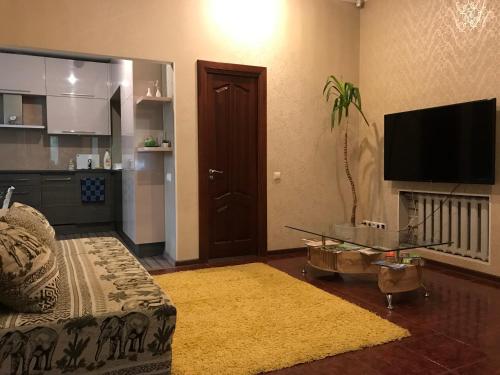 a living room with a tv and a couch and a table at DAUGAVPILS in Daugavpils