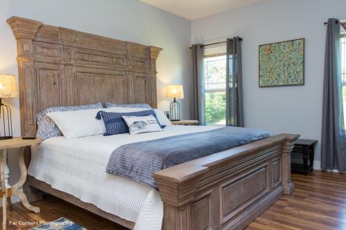 een slaapkamer met een groot bed met een houten hoofdeinde bij Mama Bears Blue Bungalow in Asheville