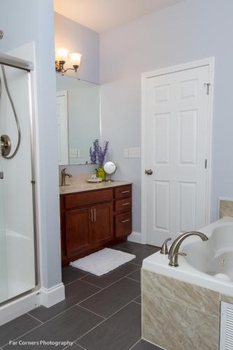 a bathroom with a tub and a sink and a shower at Mama Bears Blue Bungalow in Asheville