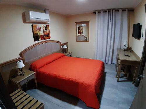 a bedroom with a red bed and a desk at Can Caragol in Cala Ratjada