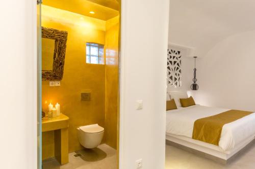 um quarto com uma cama e um WC num quarto em Margarita Hotel em Firostefani