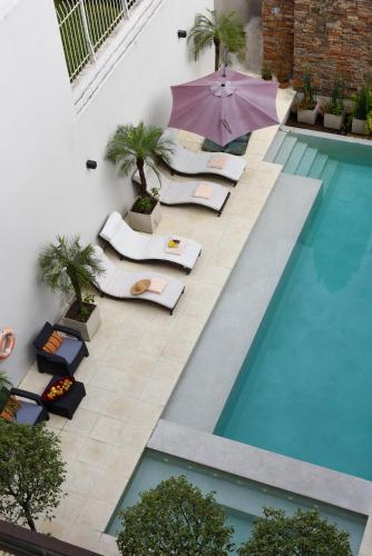 an overhead view of a pool with chairs and an umbrella at Argenta Suites Belgrano in Buenos Aires
