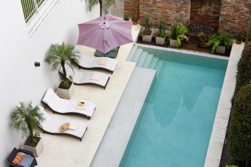 an overhead view of a pool with chairs and an umbrella at Argenta Suites Belgrano in Buenos Aires
