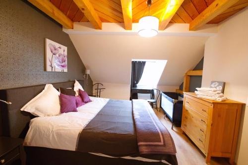 1 dormitorio con 1 cama grande y techo de madera en Gite Clos Angélique, en Hazelbourg