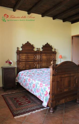 a bedroom with a large wooden bed and a table at Fattoria Delle Rose in Salussola