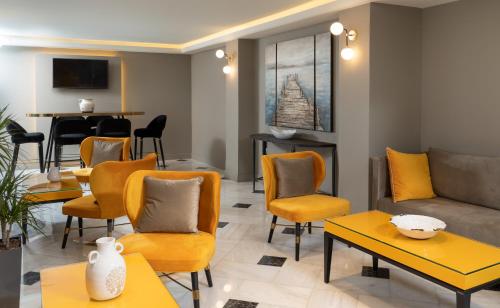 - un salon avec des fauteuils jaunes et un canapé dans l'établissement Pantheon City Hotel, à Gythio