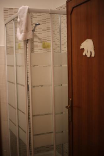 LA CASA DELL'ORSO في شيامبينو: حمام مع دش مع منشفة معلقة عليه