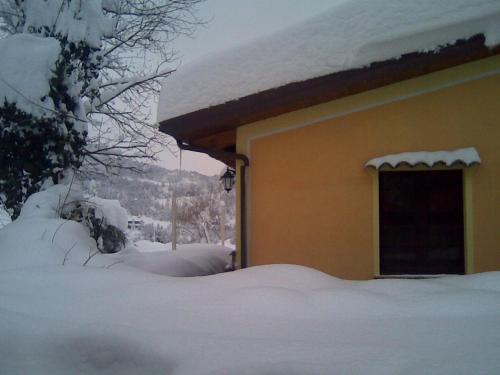 a house covered in snow with a door at Fattoria Bertaccini in Cesena