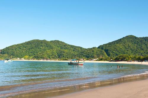 a boat in the water at a beach at Atena Praia Hotel in Boicucanga