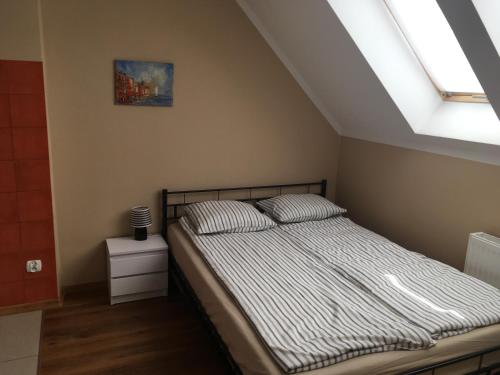 sypialnia z łóżkiem i oknem w obiekcie Apartament Wrzos w Dziwnówku