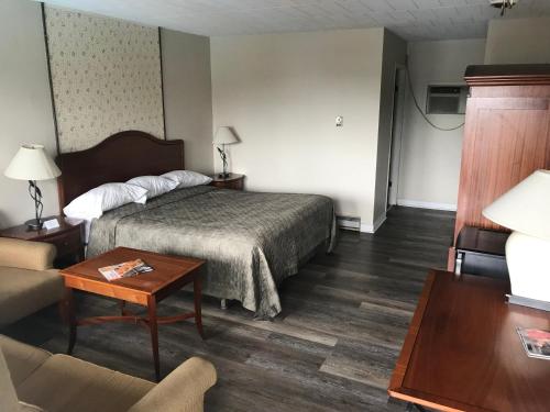 Habitación de hotel con cama y sofá en Rainbow Motor Inn - Fallsview en Niagara Falls