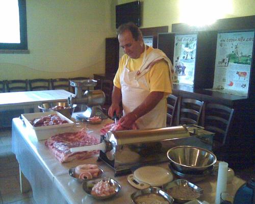 a man standing at a counter preparing food at Fattoria Bertaccini in Cesena