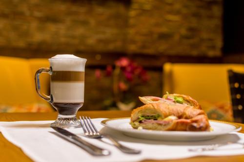 een bord met een broodje en een drankje op een tafel bij Crocs Resort & Casino in Jacó