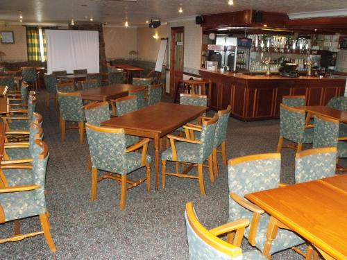 a dining room with wooden tables and chairs at Tafarn Y Rhos in Llangefni