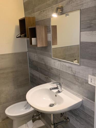 bagno con lavandino, specchio e servizi igienici di Casa Manni Torre Suda a Racale