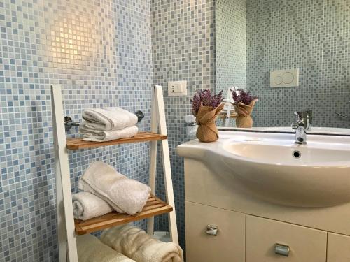 een badkamer met een wastafel, een spiegel en handdoeken bij Monolocali White Angel Apartments in Porto Cesareo