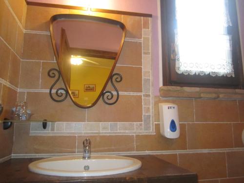 a bathroom with a sink and a mirror on the wall at Fattoria Bertaccini in Cesena