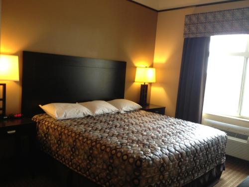 a bedroom with a bed with two pillows and a window at Super 8 by Wyndham Odessa TX in Odessa