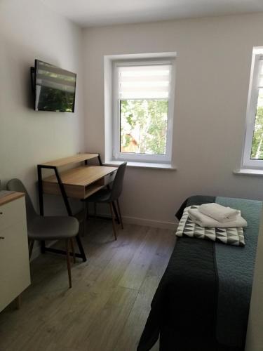 a room with a desk and a bed and a table at Pokoje Na Szlaku in Lądek-Zdrój