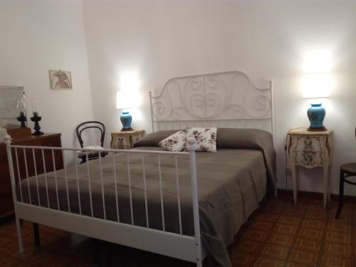 a bedroom with a white bed with two tables and two lamps at Terrazza sul Mare in Lipari