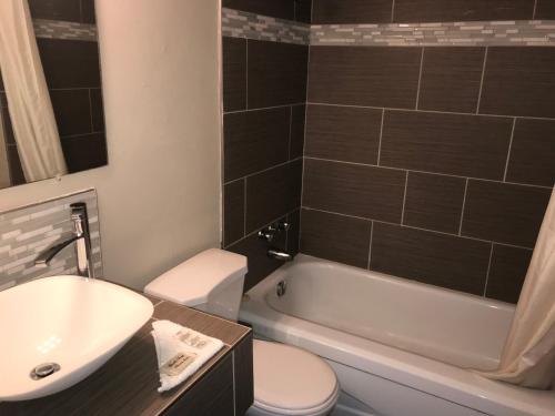 尼亞加拉瀑布的住宿－彩虹汽車旅館- 瀑佈景，浴室配有盥洗盆、卫生间和浴缸。