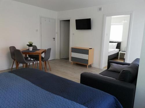 a bedroom with a bed and a table and a couch at Pokoje Na Szlaku in Lądek-Zdrój