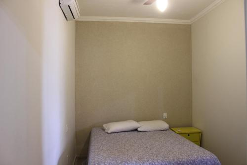 um quarto com uma cama com dois travesseiros em Casa Magnífica em Olímpia