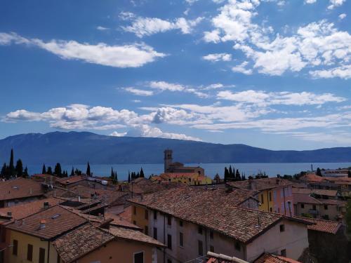 a view of a town with buildings and the water at Ostello delle cartiere in Toscolano Maderno