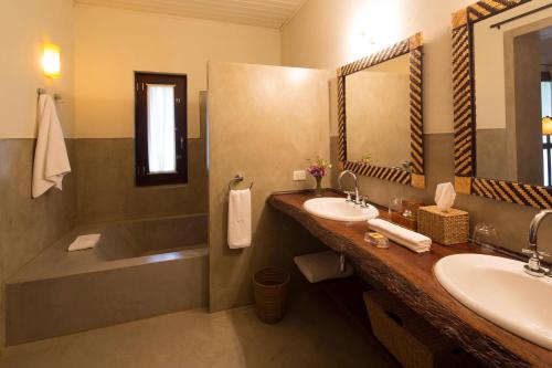 Un baño con bañera, lavabo y bañera. en Puerto Valle Hotel de Esteros, en Puerto Valle