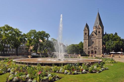 a fountain in front of a building with a church at Metz Port Saint Marcel in Metz