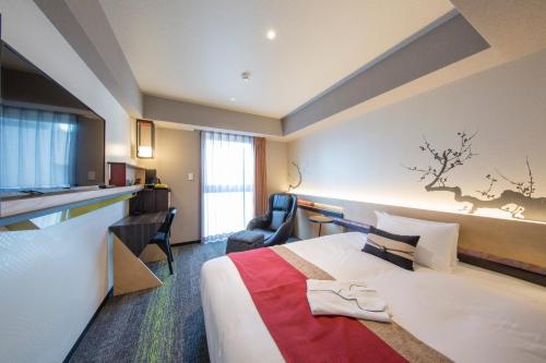 a hotel room with a large bed and a kitchen at Shizutetsu Hotel Prezio Kyoto Karasumaoike in Kyoto
