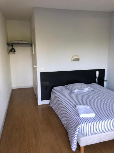een slaapkamer met een bed met een zwart-wit dekbed bij VILLA HOTEL in Malesherbes