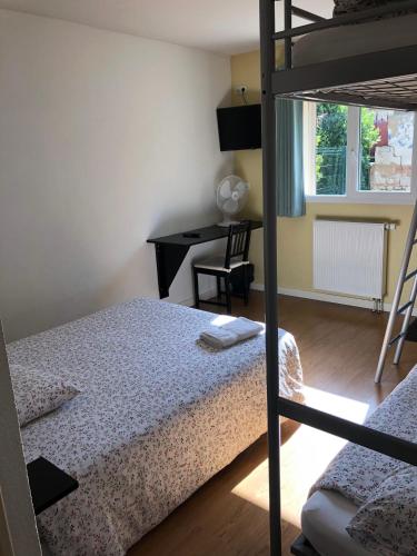 een slaapkamer met een stapelbed en een bureau bij VILLA HOTEL in Malesherbes