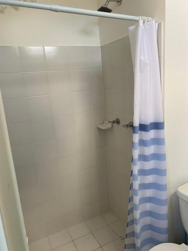 a bathroom with a shower with a blue and white shower curtain at Apartamento - Tocaima in Tocaima