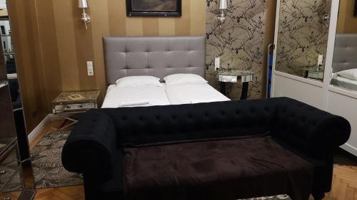 a bedroom with a large bed and a couch at Boudoir Budapest Apartment in Budapest