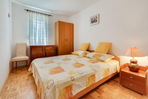 Apartment Sweet في زادار: غرفة نوم بسرير وطاولة مع مصباح