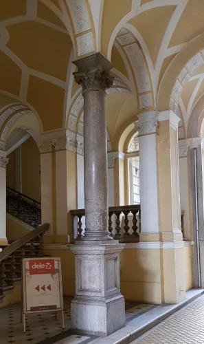 a large column in a building with a sign on it at Boudoir Budapest Apartment in Budapest