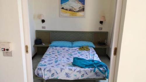 1 dormitorio con 1 cama con almohadas azules en Bouganville Residence, en Isola Rossa