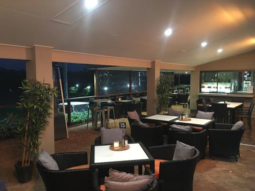 a restaurant with tables and chairs and a bar at Fairway Village @ Windaroo Lakes Golf Club in Windaroo