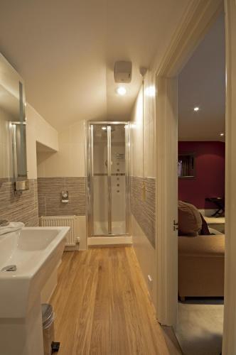 a bathroom with a shower and a sink and a bed at Boscundle Manor in St Austell