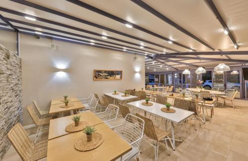 um restaurante com mesas e cadeiras num quarto em Dias Hotel em Alexandroupoli